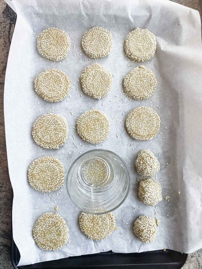 Flattening cookie dough balls with a glass