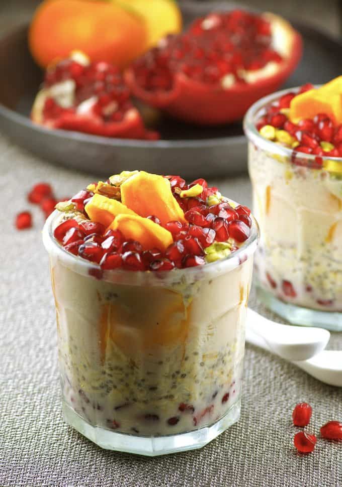 side view of a jar with overnight oats topped with persimmons and pomegranates