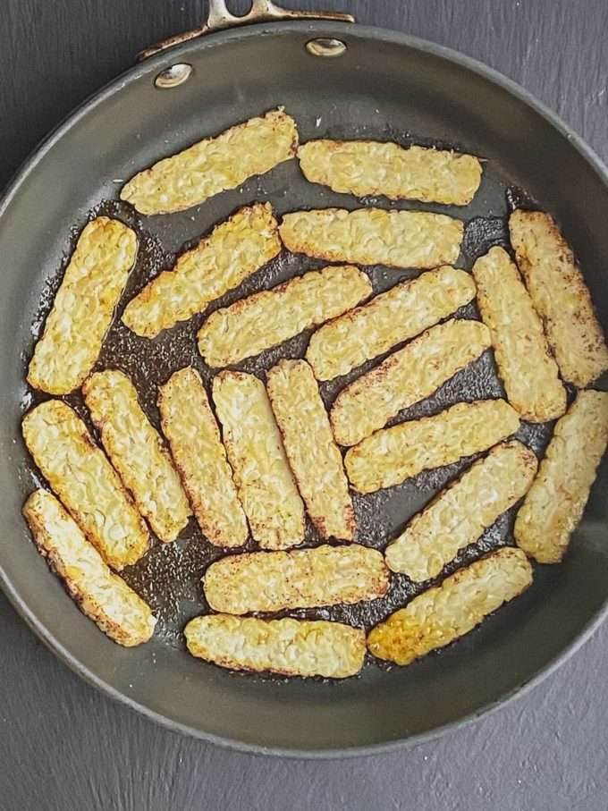 Tempeh cooking on a skillet