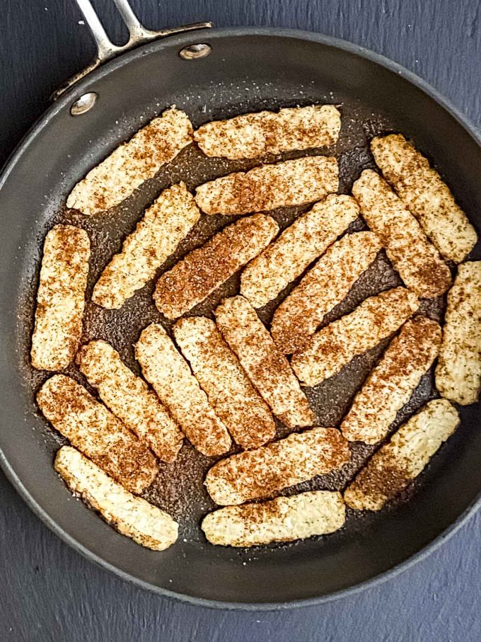 Spiced tempeh cooking on a skillet