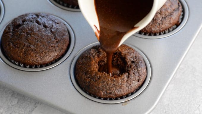 Filling a vegan chocolate cupcake with whiskey cream sauce