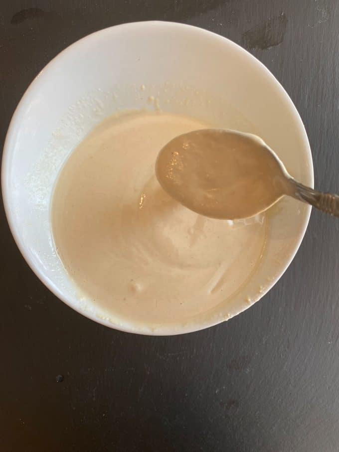 Mixing the tahini dressing in a bowl