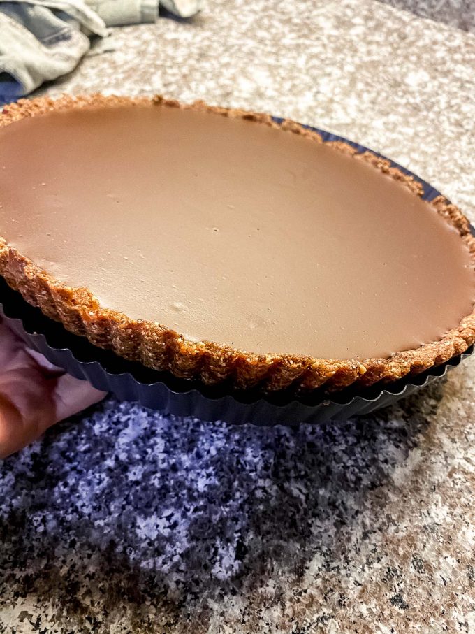 Showing the date and posted hazelnut crust on the vegan chocolate tart