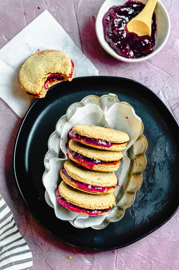 four quinoa breakfast cookie sandwiches with raspberry jelly in the middle