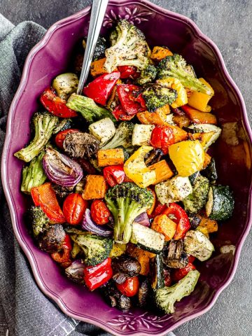 Oven roasted vegetables on a purple serving dish.