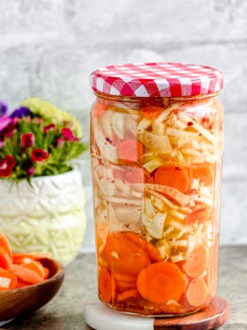 A closed jar of pickled carrots and fennel