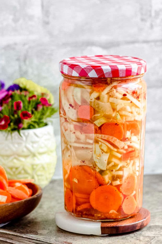 A closed jar of pickled carrots and fennel