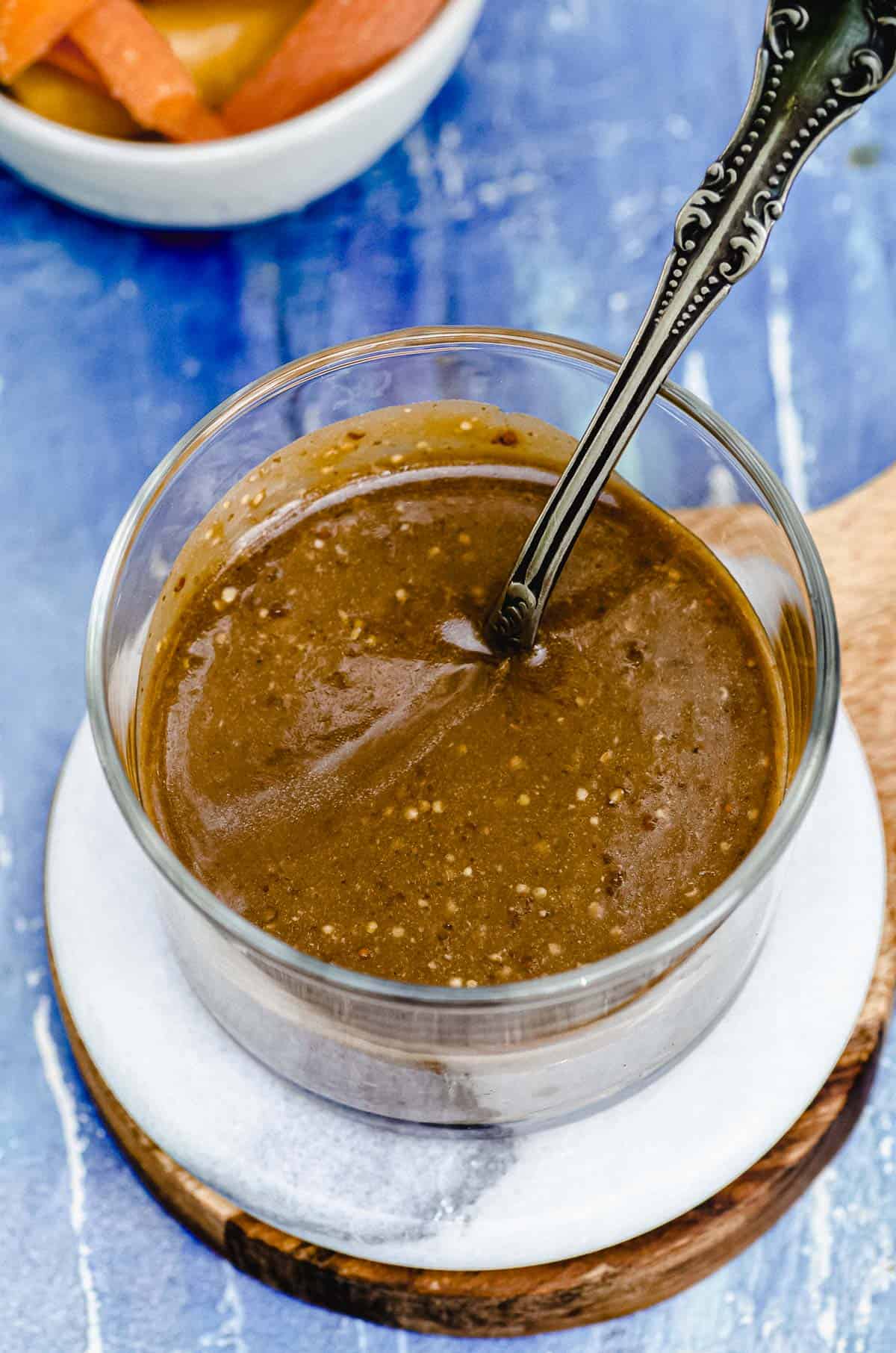 Overhead view of a clear bowl with creamy balsamic dressing