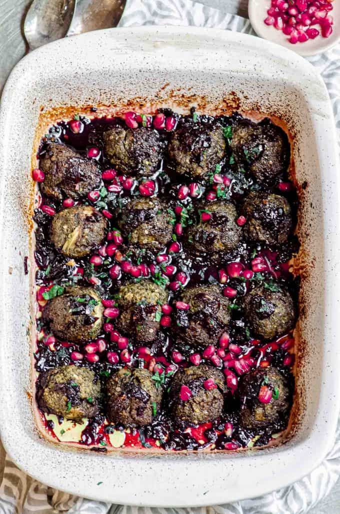 A white baking dish with eggplant meatballs with pomegranate molasses