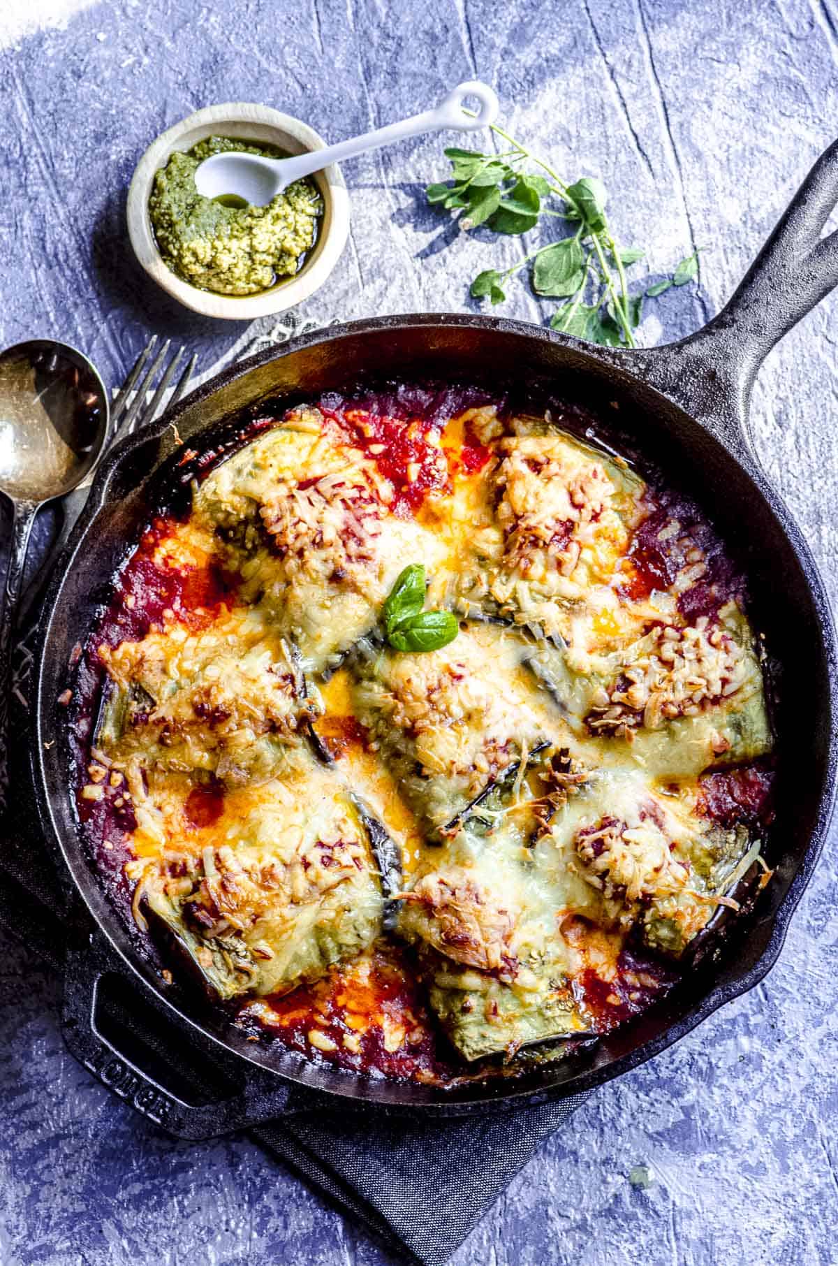 an overhead view of baked eggplant rollatini in a cast iron skillet