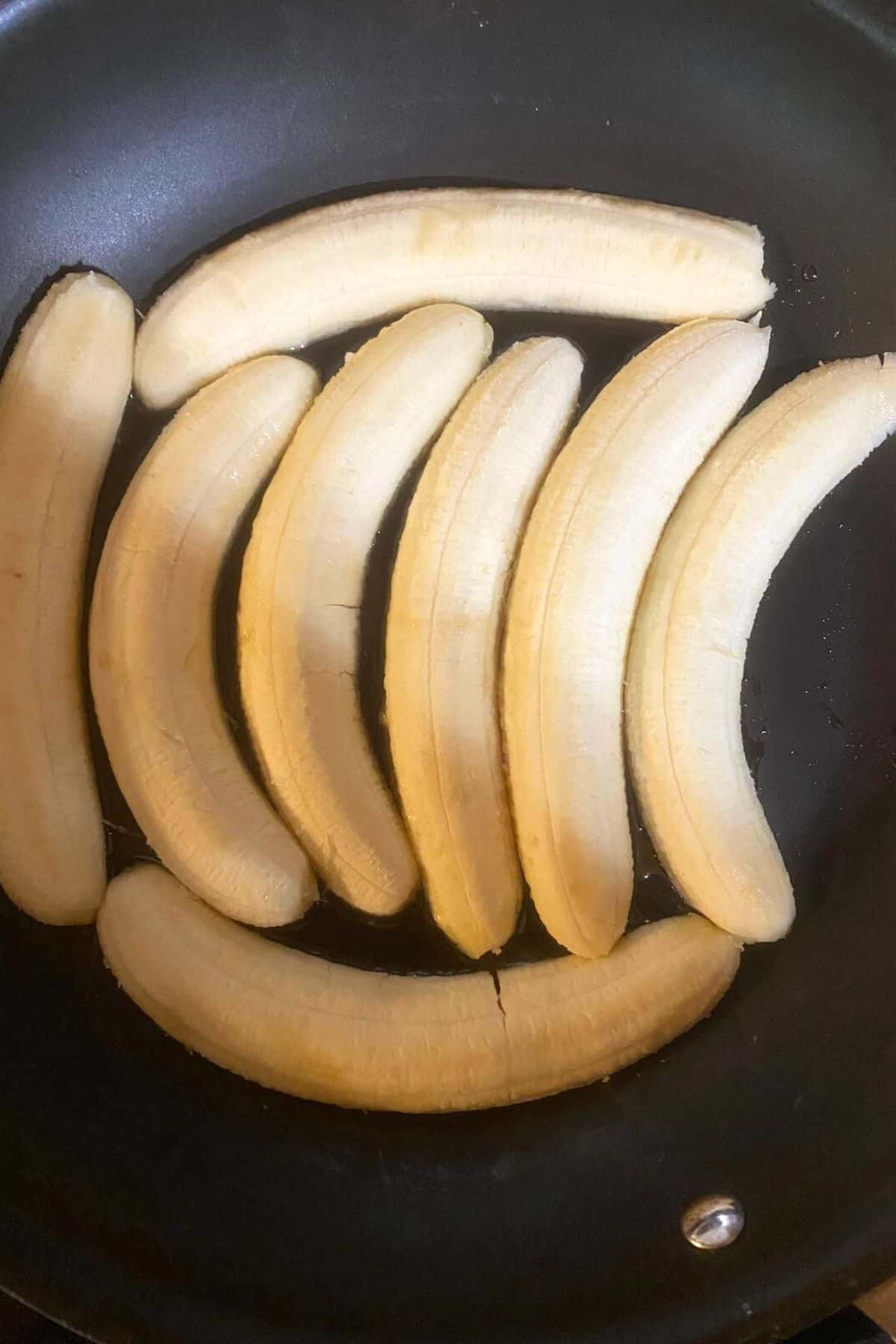An overhead view of sliced bananas slice side down on a pan