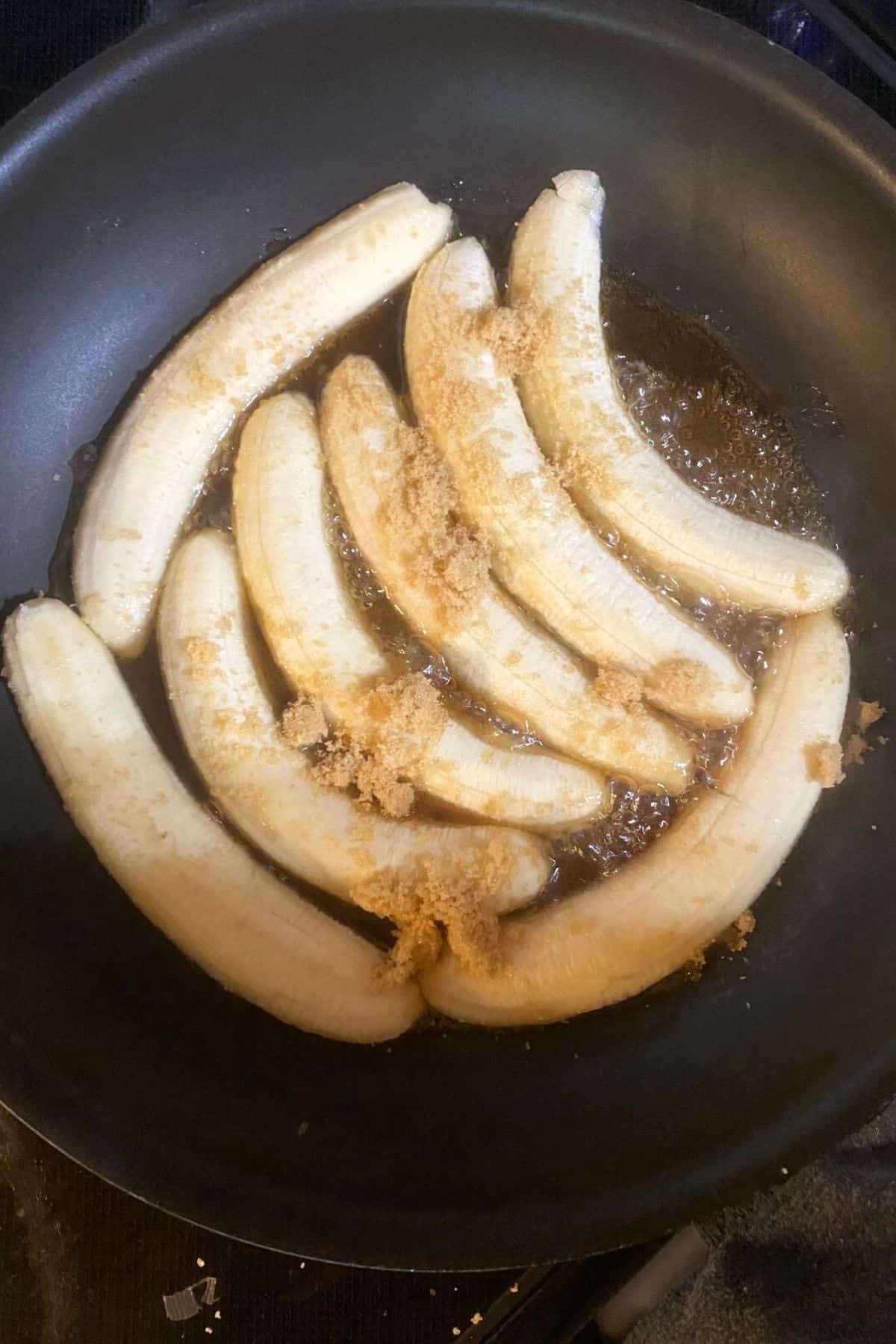 An overhead view of sliced bananas sitting in agave with brown sugar sprinkled on top