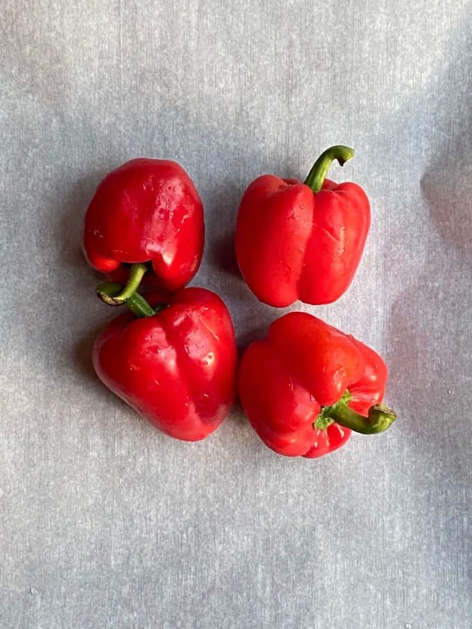 An overhead view of a four whole red peppers