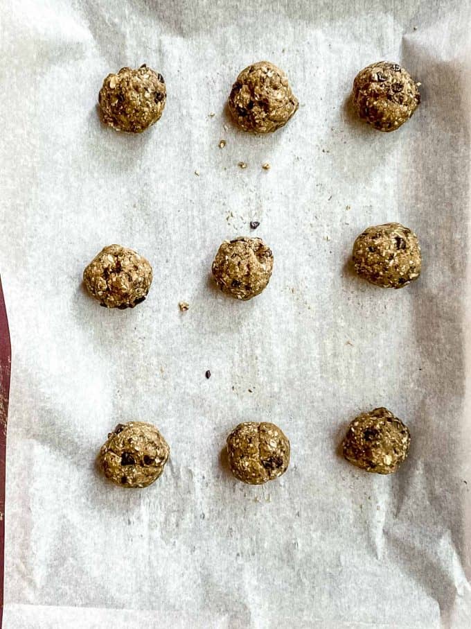 Chocolate chip cookie dough balls on a baking sheet lined with parchment paper