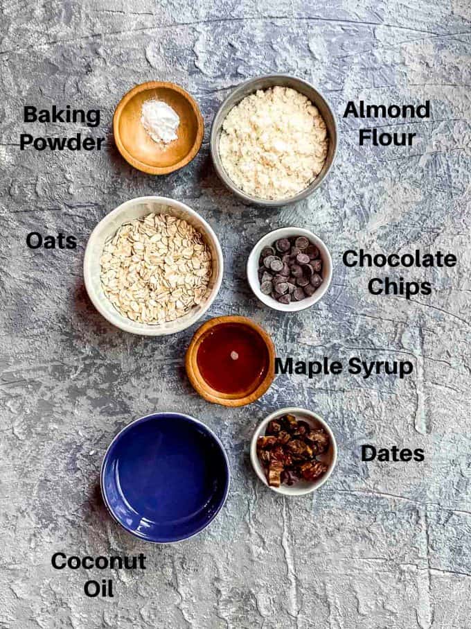 Ingredients for Oatmeal chocolate chip cookies labeled. oats, almond flour, maple syrup, coconut oil, dates and baking powder