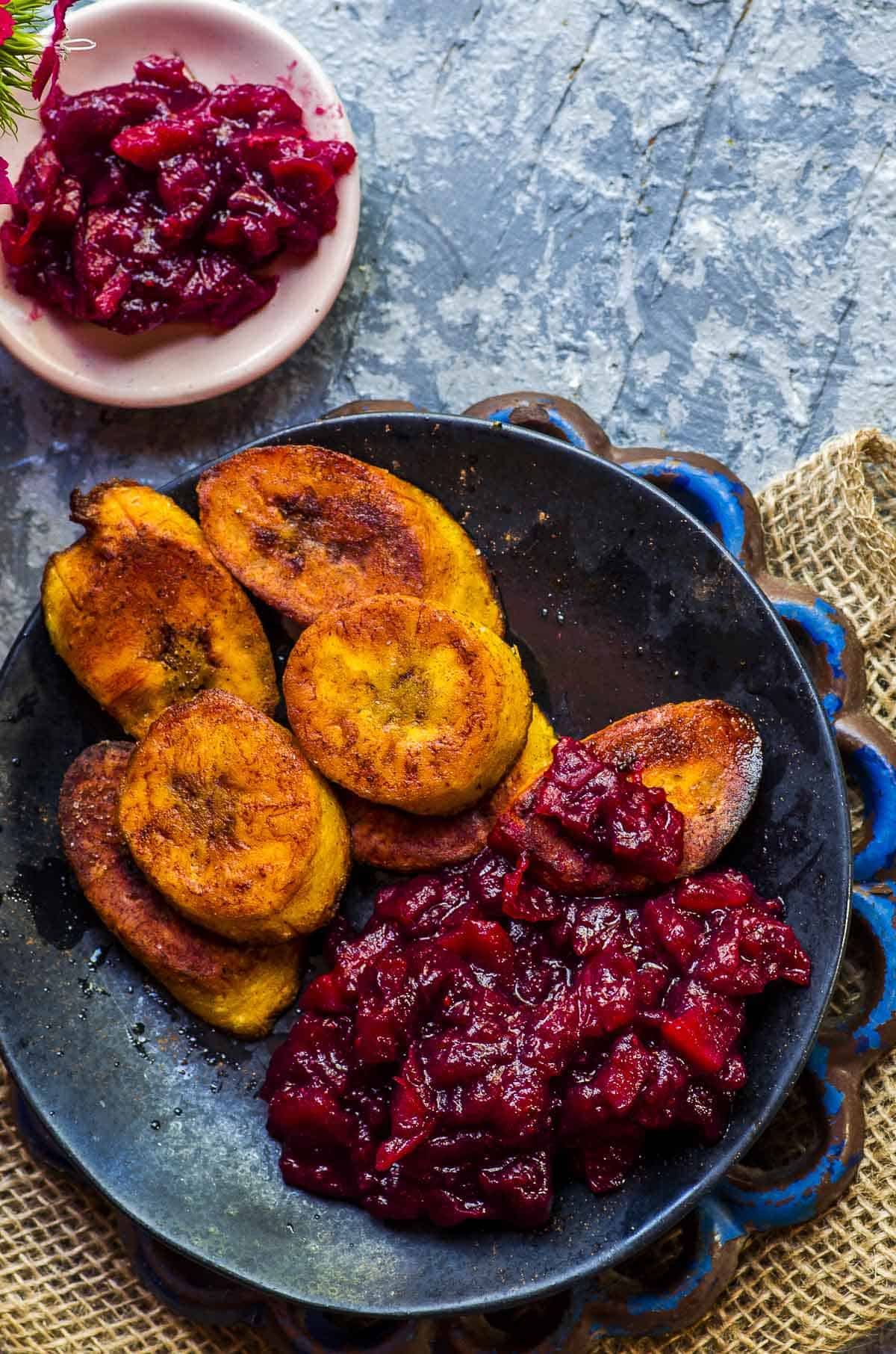 close up view of a plate with fried plantains and cranberry sauce