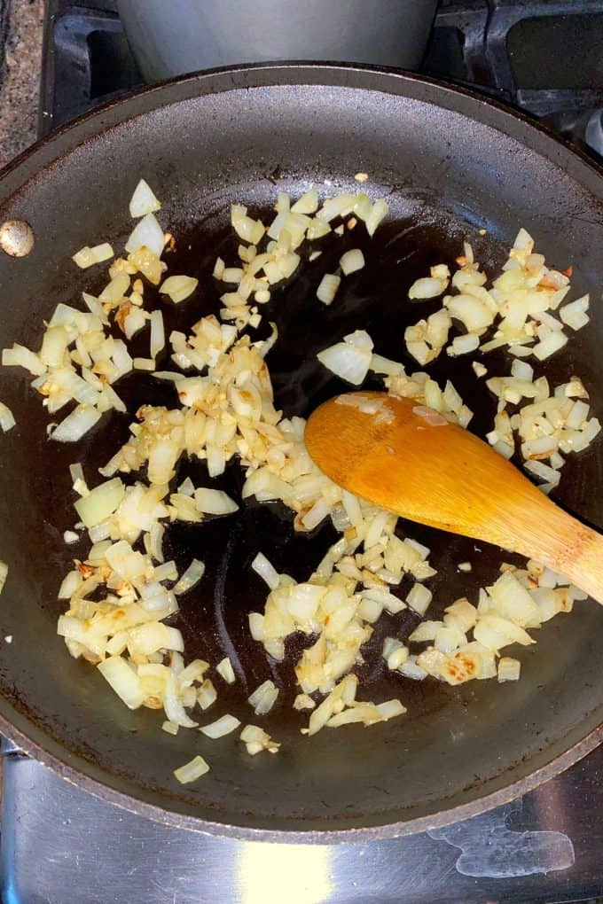 Onions and garlic being sauteed in a skillet