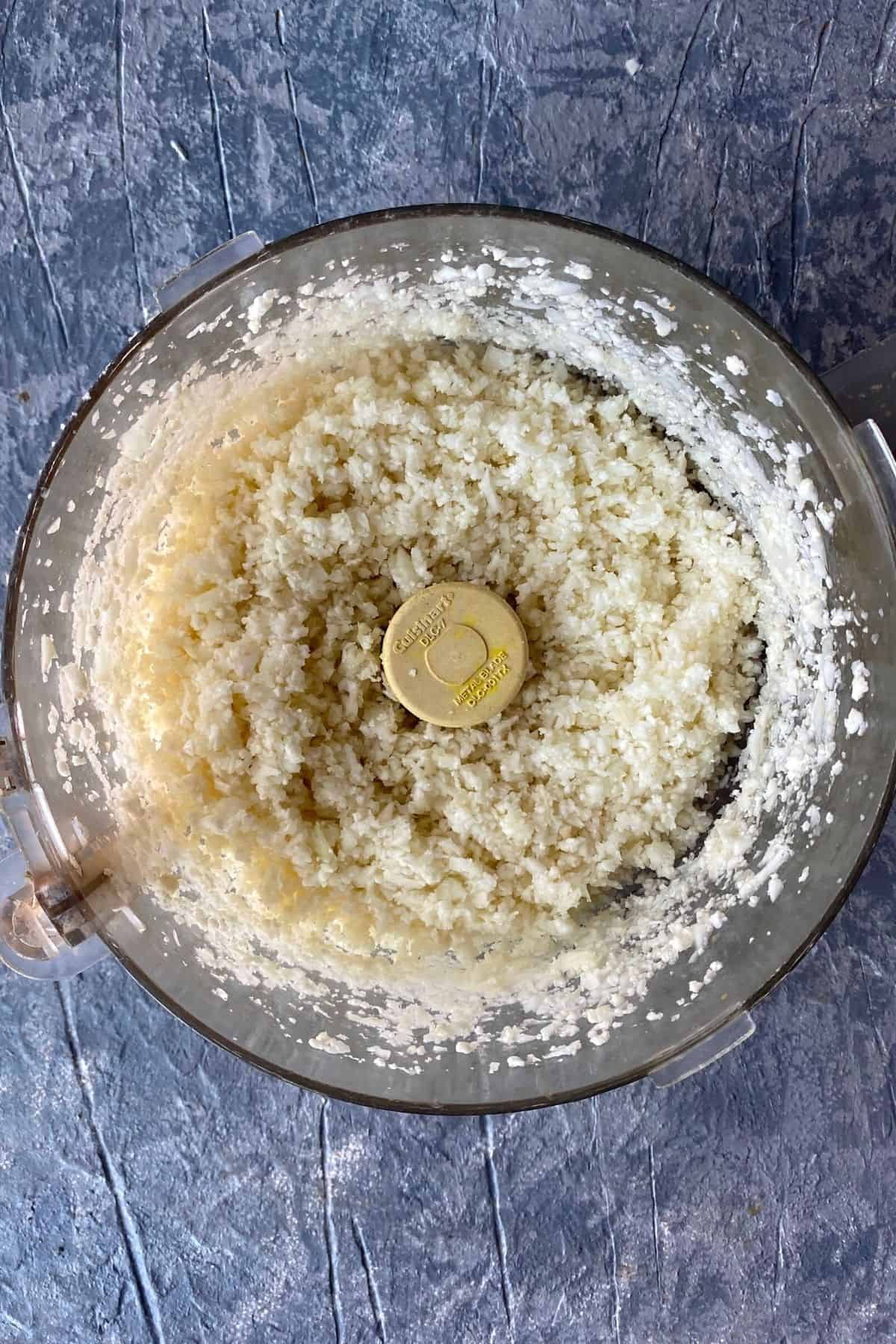 Blended up pieces of cauliflower in a food processor