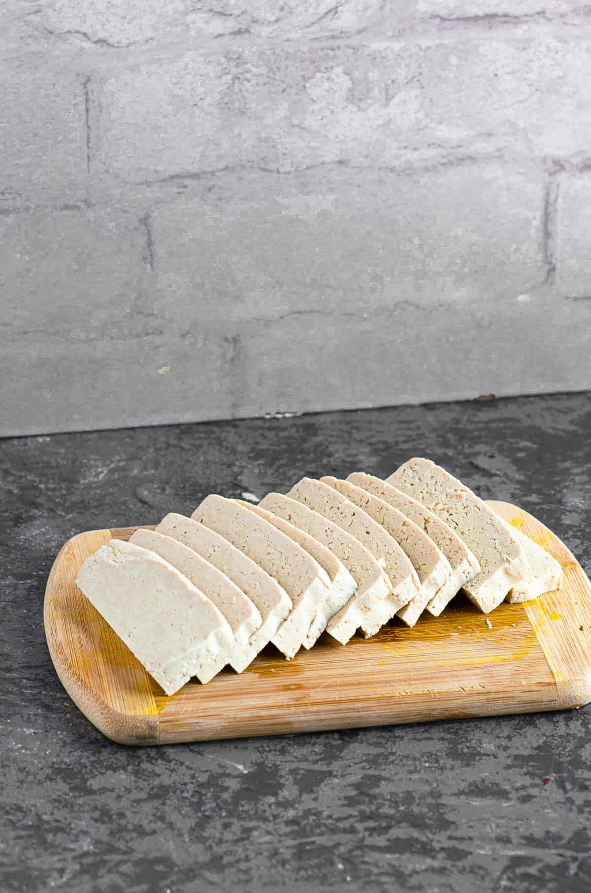 Tofu slices displayed on a wood cutting board