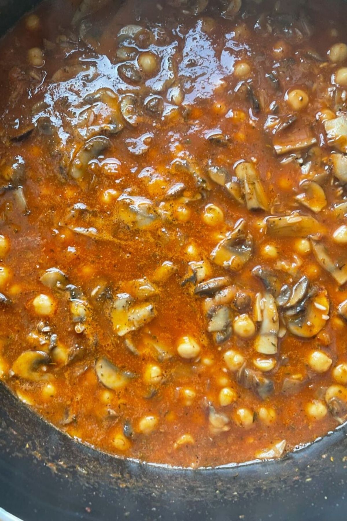 Tomatoes, mushroom and chickpea in a pot simmering