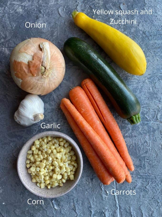 Ingredients for crustless quiche. Yellow squash, green zucchini, corn, carrots, onions and garlic