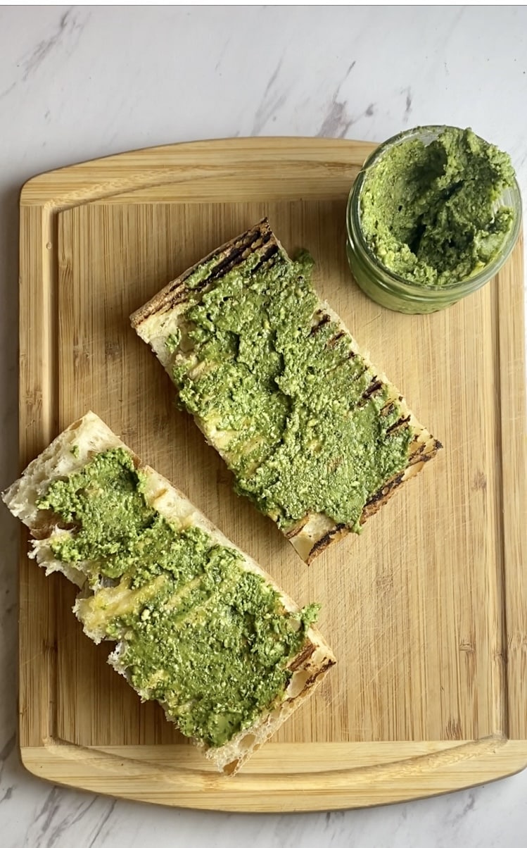 Two slices of bread with pesto spread 