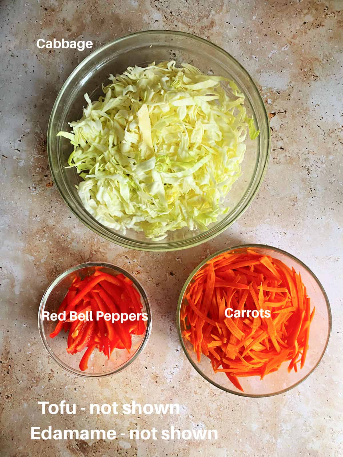 Ingredients to make cabbage stir fry in bowls. Cabbage, carrots, red bell peppers