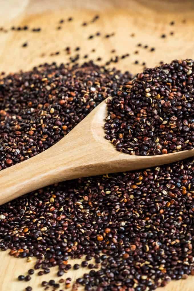 black quinoa in a wooden spoon

