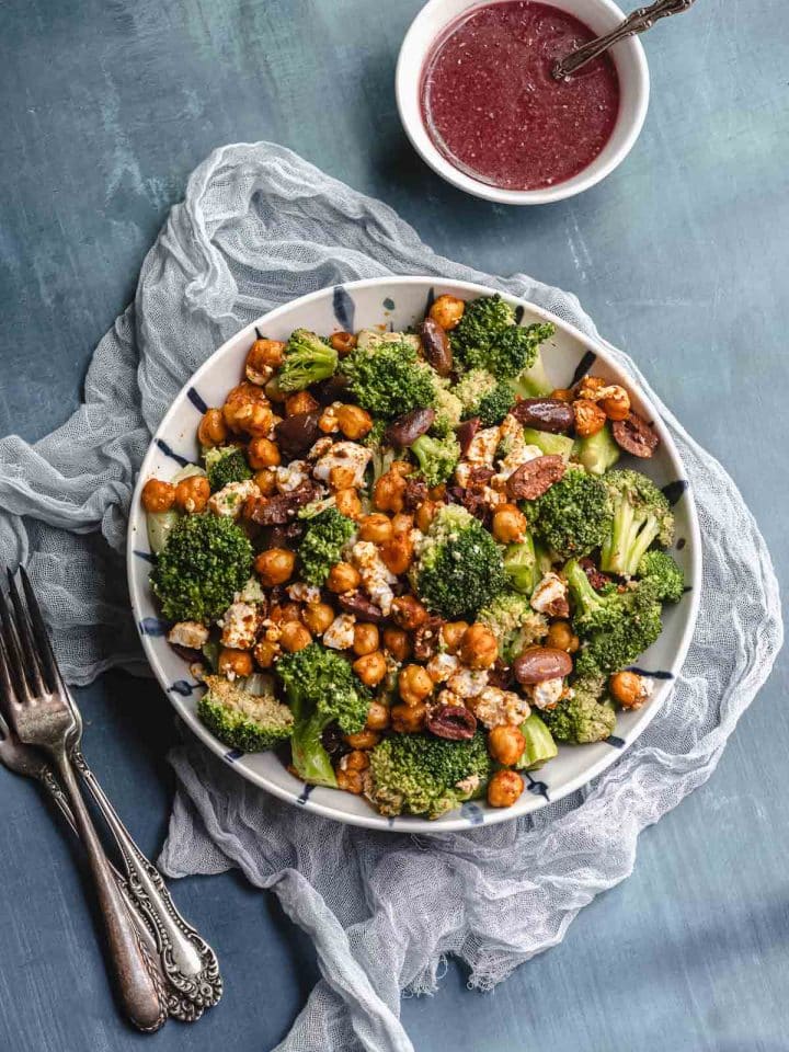 Overhead view of a bowl with broccoli salad next to a bowl with raspberry vinaigrette