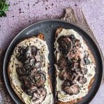 Closeup view of two toast with sautéed mushrooms and hummus