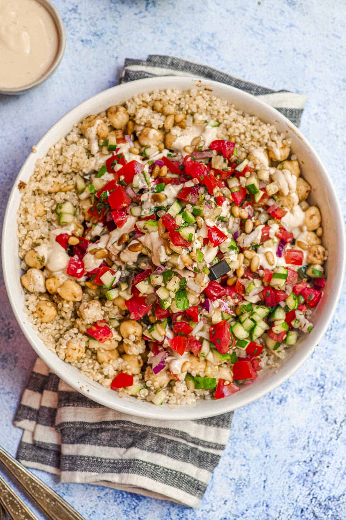 Closeup overhead view of a quinoa bowl topped with Israeli salad
