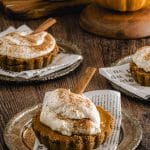 Close up view of a mini pumpkin pie with a dollop of whipped cream