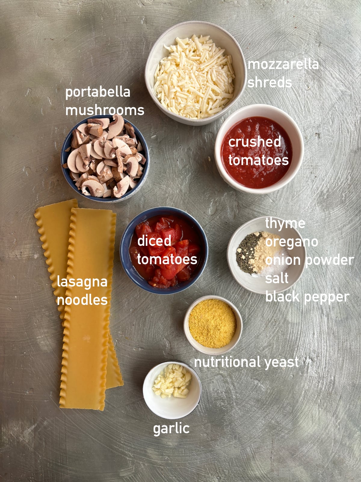 overhead image of ingredients needed to make lasagna soup. Ingredients are in small bowls and labeled with white text