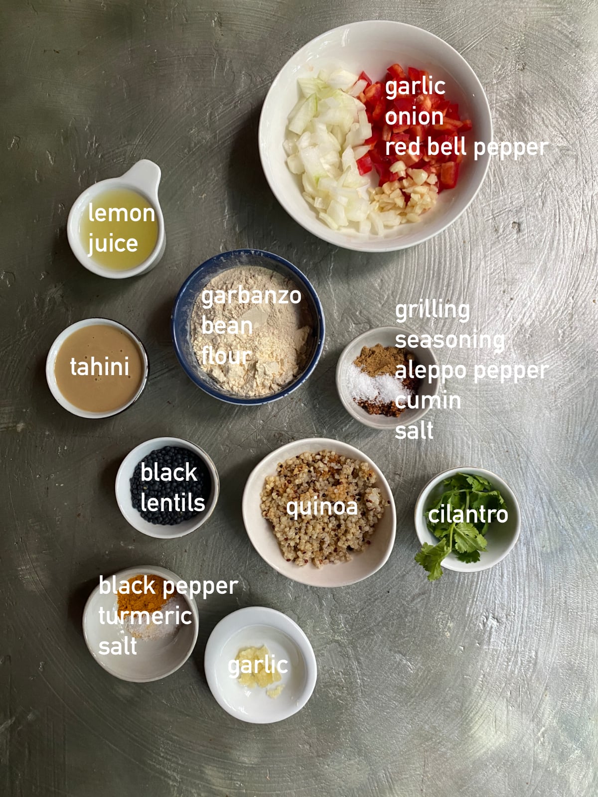 overhead image of the ingredients needed to make lentil meatballs with turmeric sauce. The ingredients are each in small bowls and labeled with white text