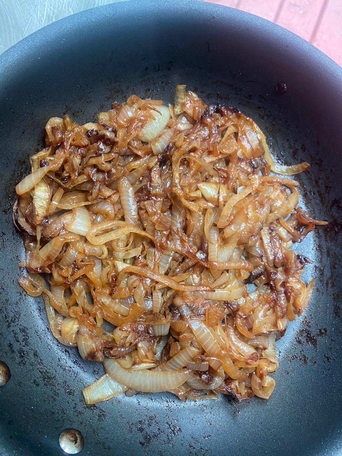 overhead image of a nonstick skillet sautรฉing onions to golden brown