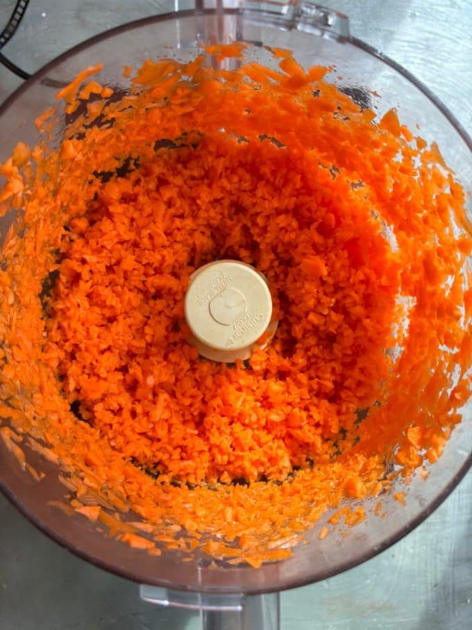 overhead image of shredded carrots in a food processor