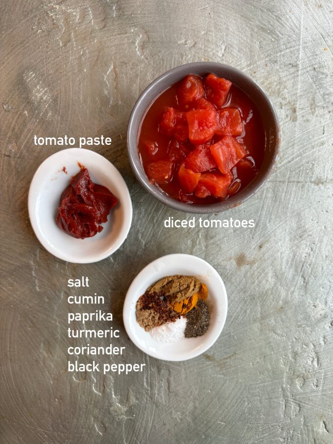 an overhead image of ingredients for vegetable soup. Ingredients are in small bowls and labeled with white text