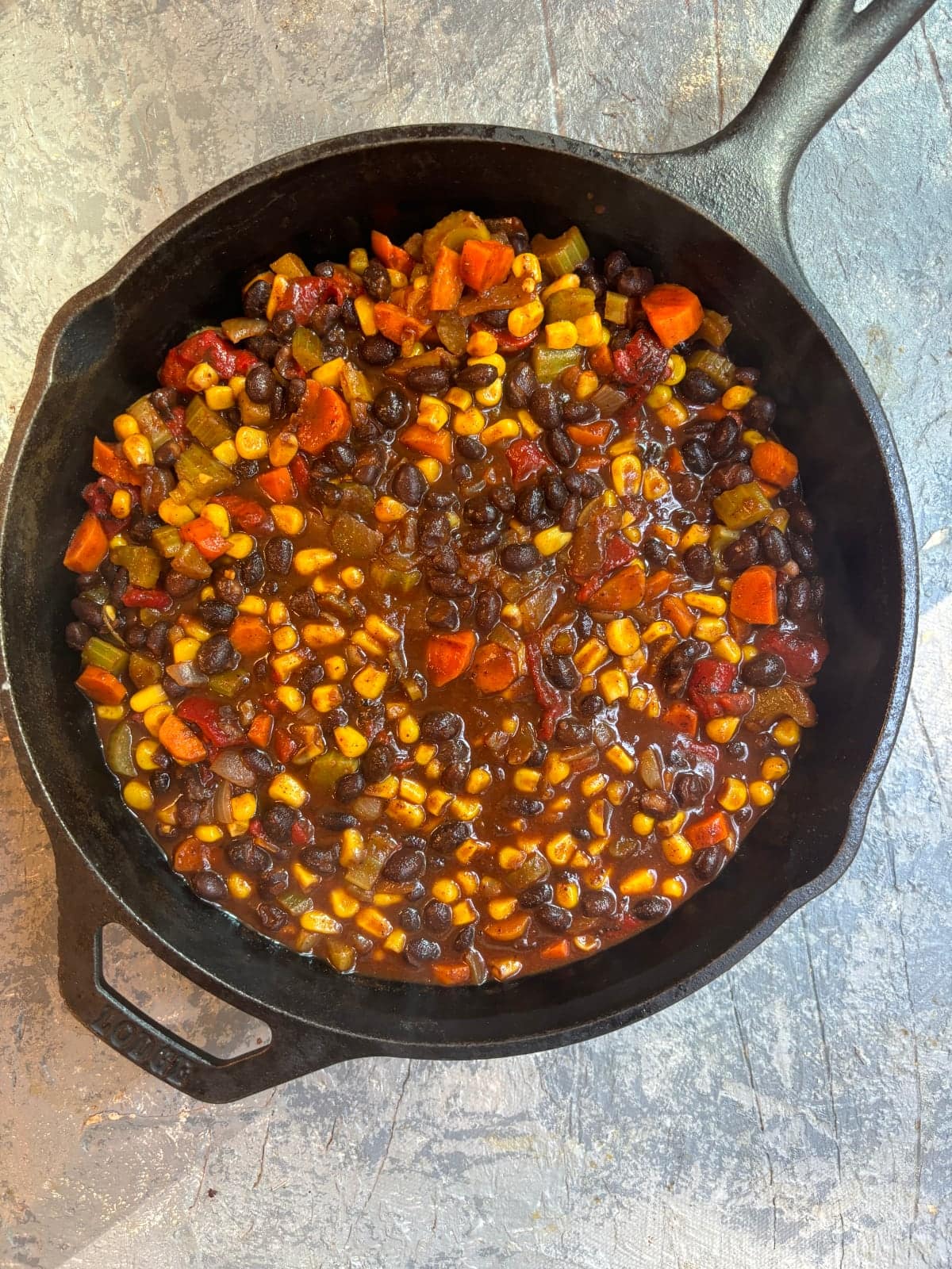 overhead image of a cast iron skillet filled with black bean chili
