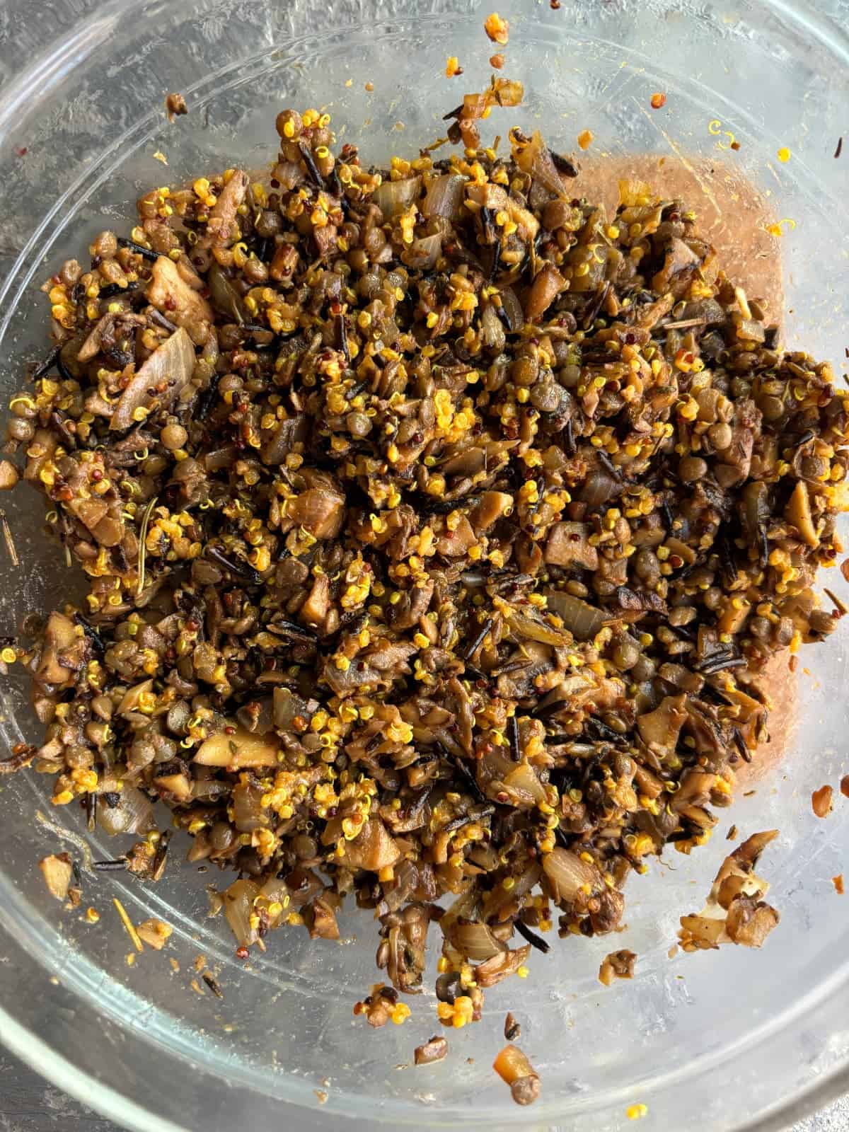 overhead image of a glass mixing bowl filled with the stuffing for stuffed honeynut squash recipe.